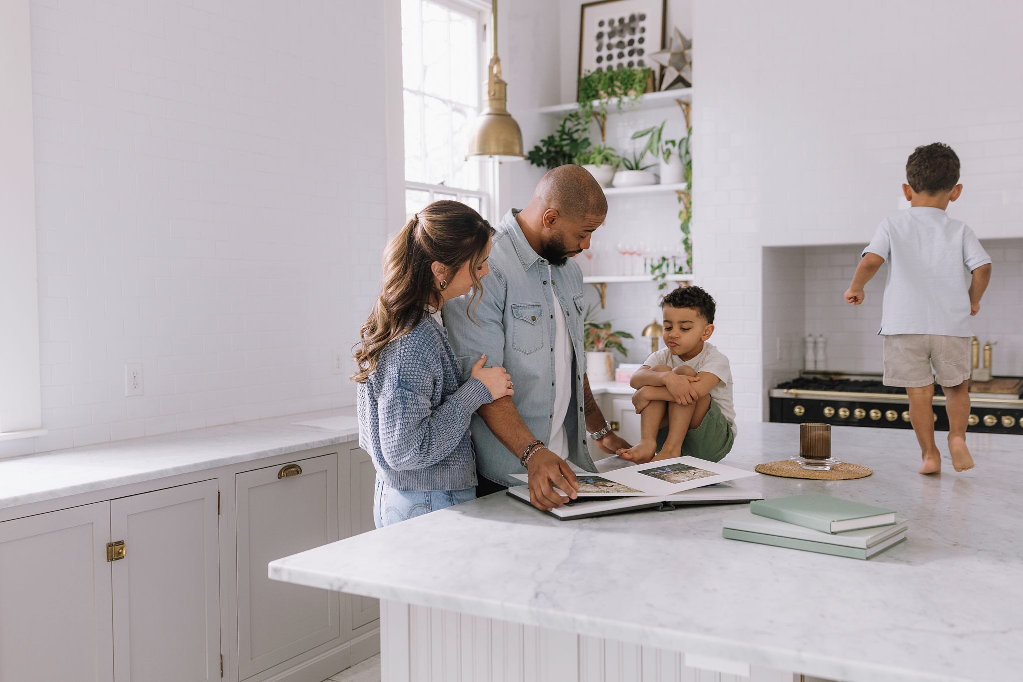 Family gathered around a Fine Art Album on a kitchen island