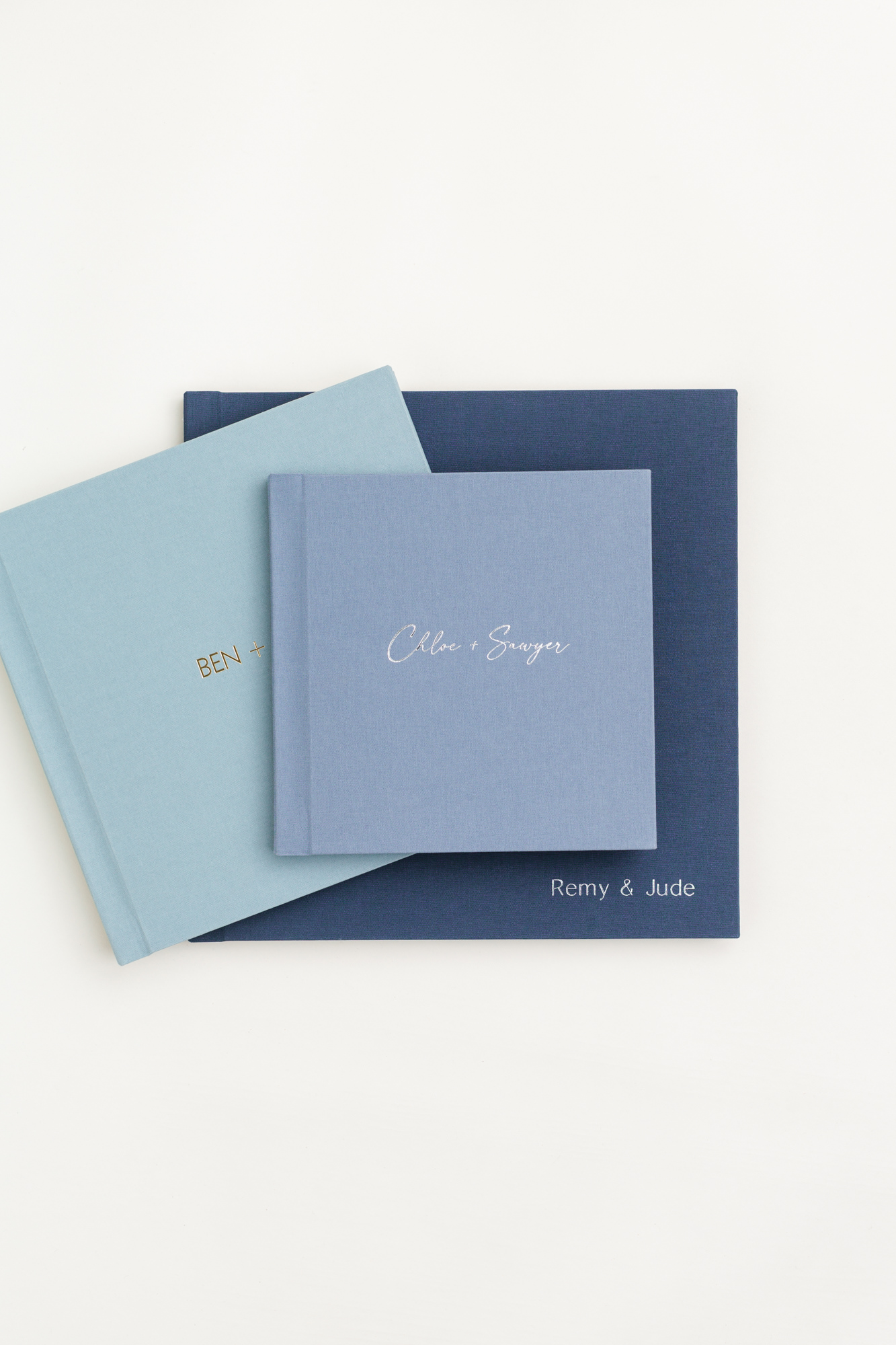 A stack of Lite Albums in blue Classic Linen covers