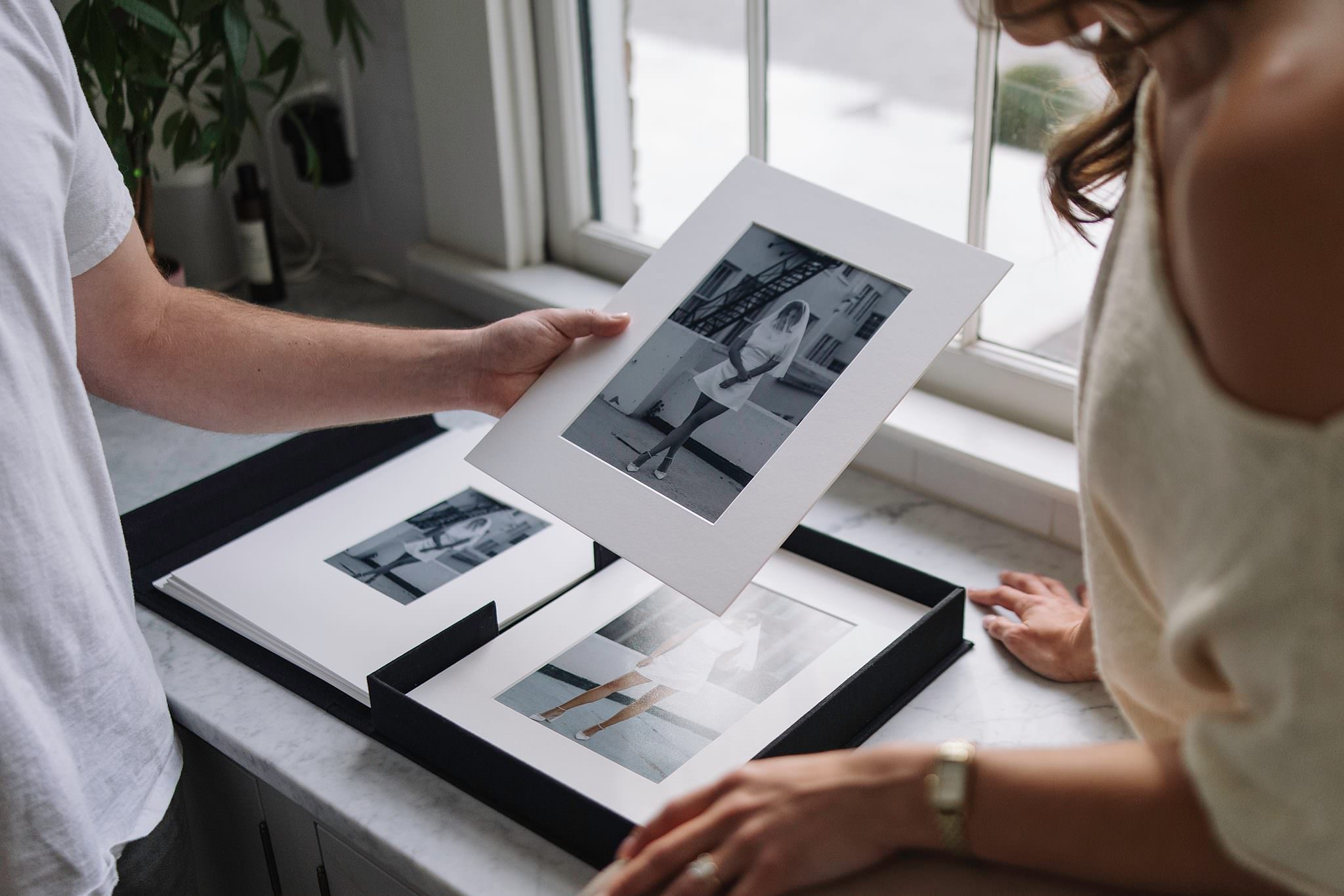 A matted print from a print box being held in two hands
