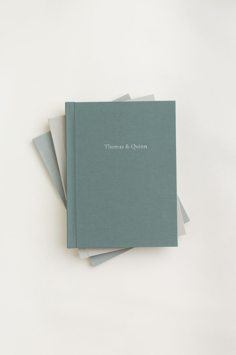 Stack of Lite layflat albums in soft linen covers