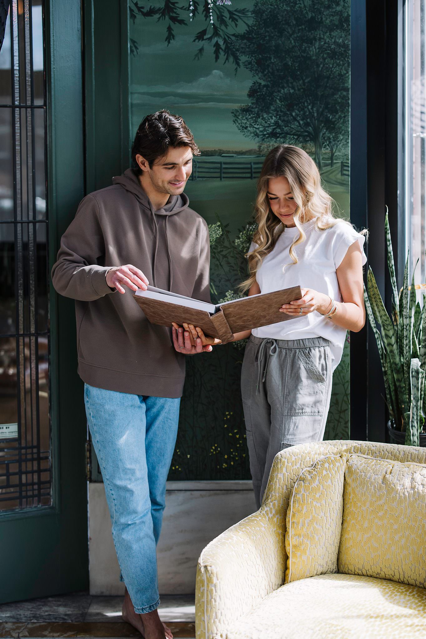 A couple looking at their RedTree Album by a window